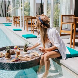 slim-woman-elegant-brown-hat-eating-juicy-fruits-resort-cafe-graceful-european-woman-white-shirt-relaxing-with-cocktail-food-pool